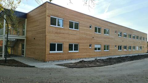 Zweigeschossige Stahlcontaineranlage mit Holzfassade